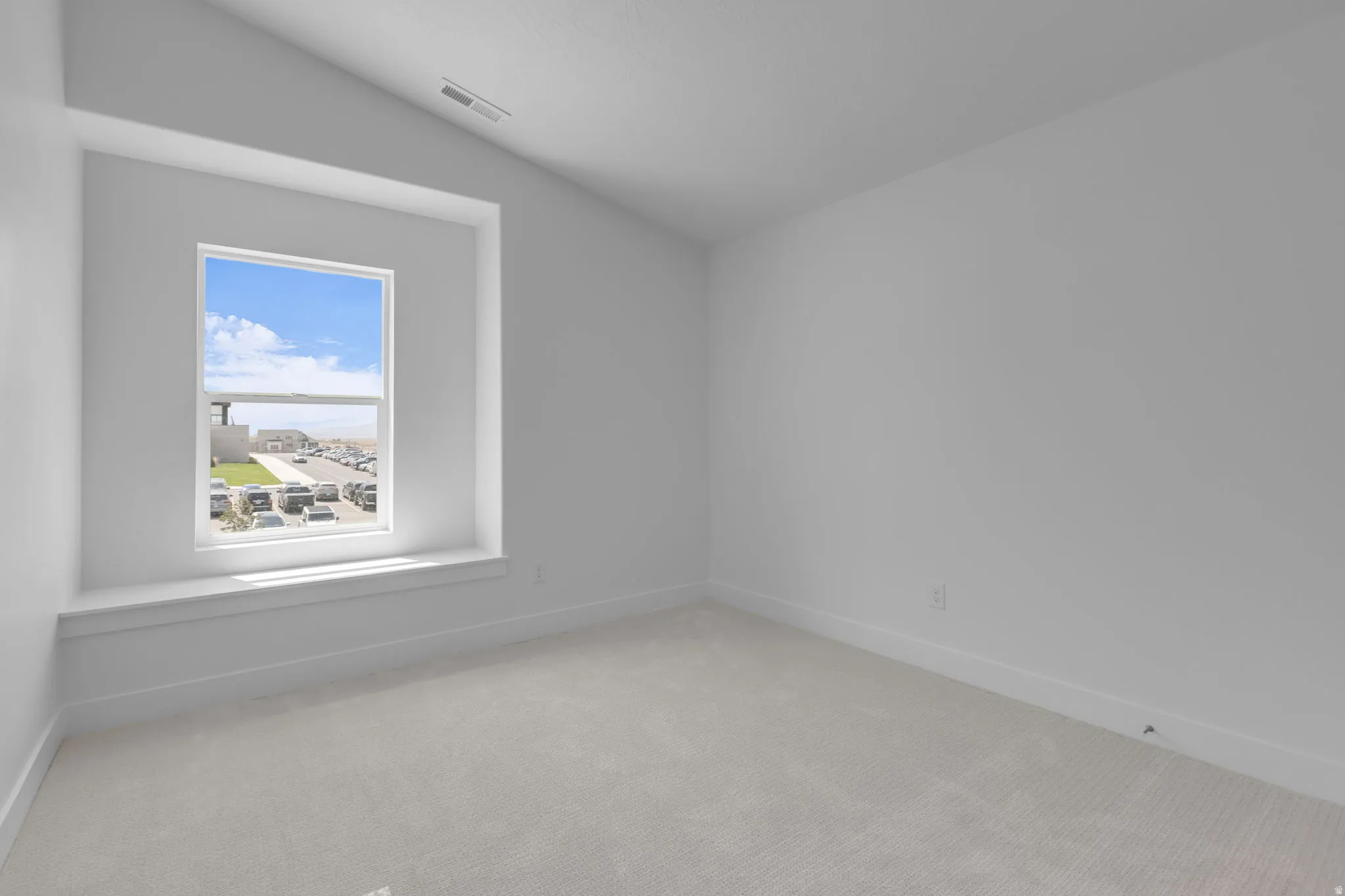 Vaulted bedroom #3 with a deep-set window seat and large window.