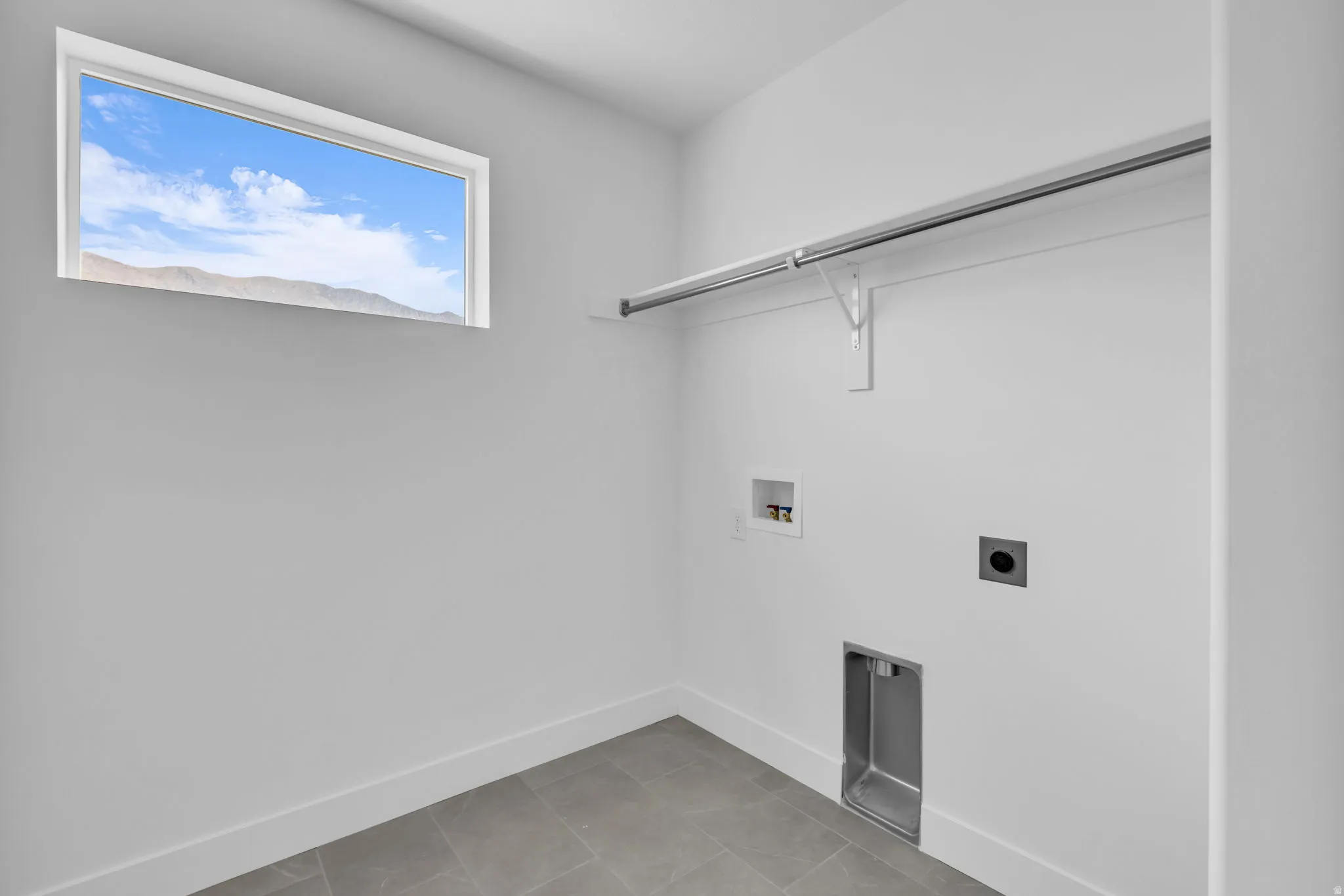 Laundry room with picture window, tile floor and washer/dryer hookups.