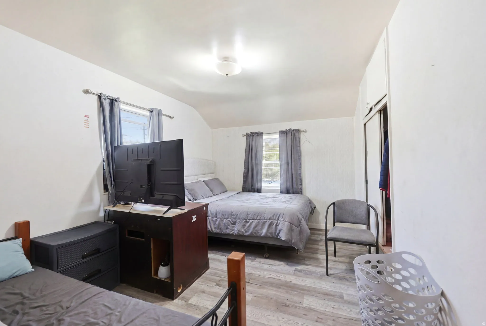 Bedroom featuring wood-finish flooring, white walls, and a ceiling-mounted light fixture