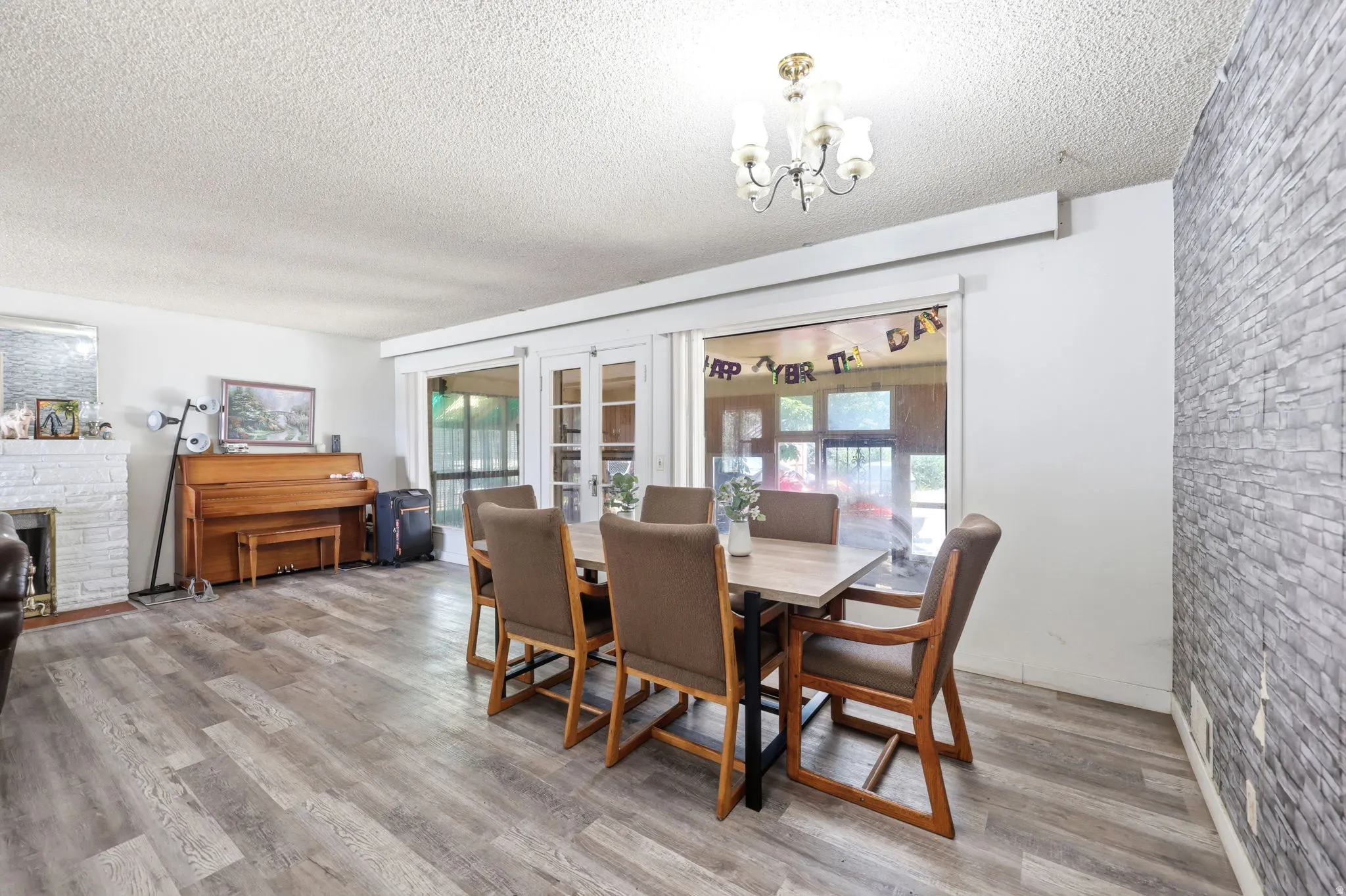 Spacious dining area featuring wood-finish flooring and a stone accent wall