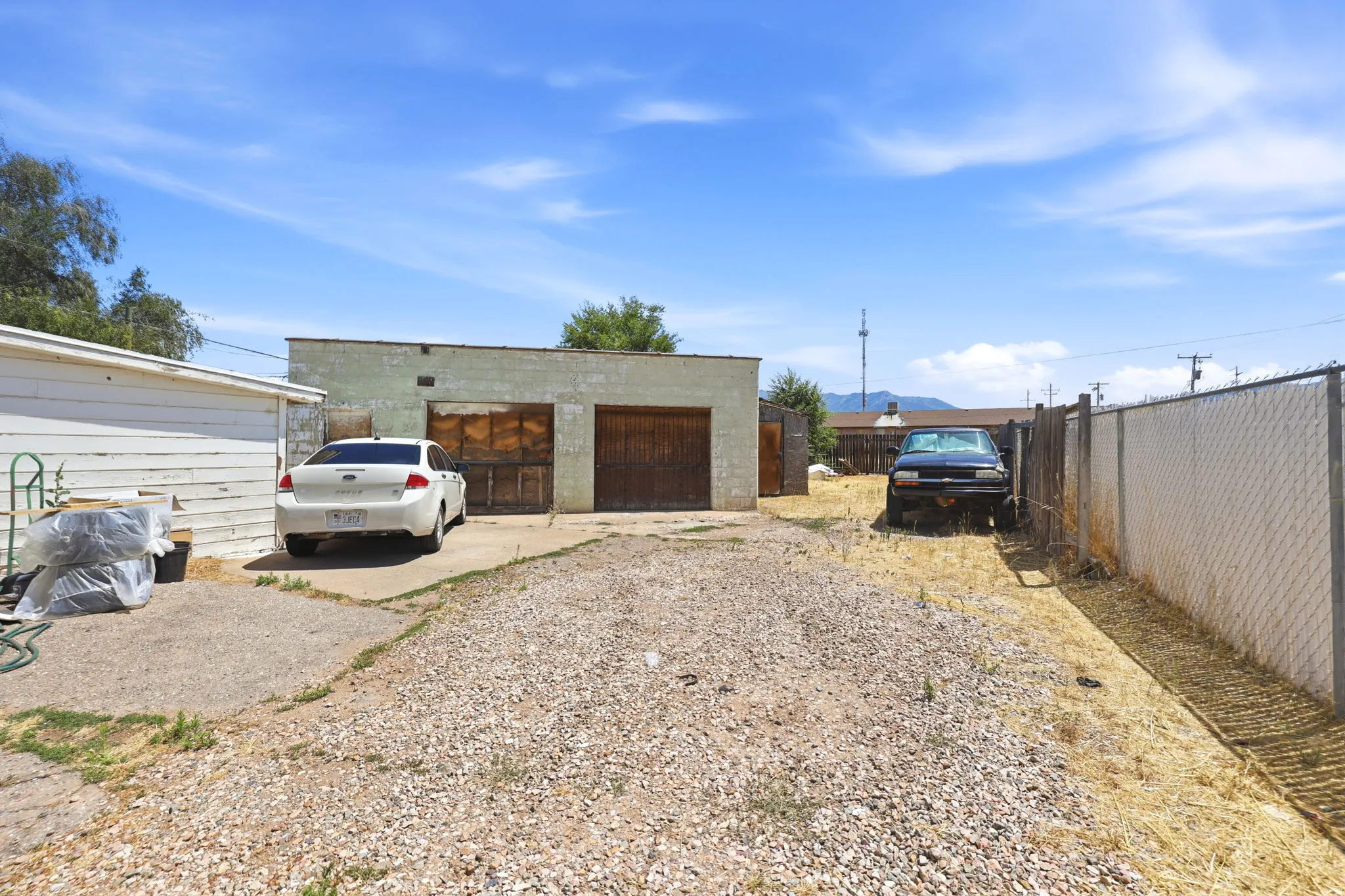 Detached two-car garage with wood doors and concrete driveway