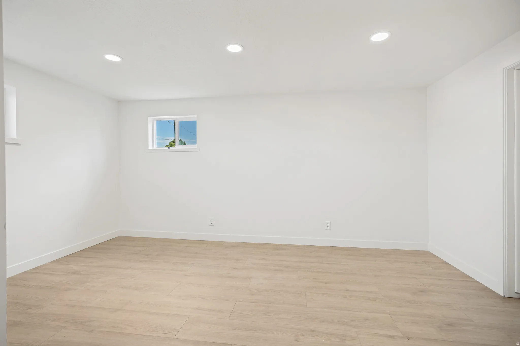 Bright room featuring wood-finish flooring and recessed ceiling lighting