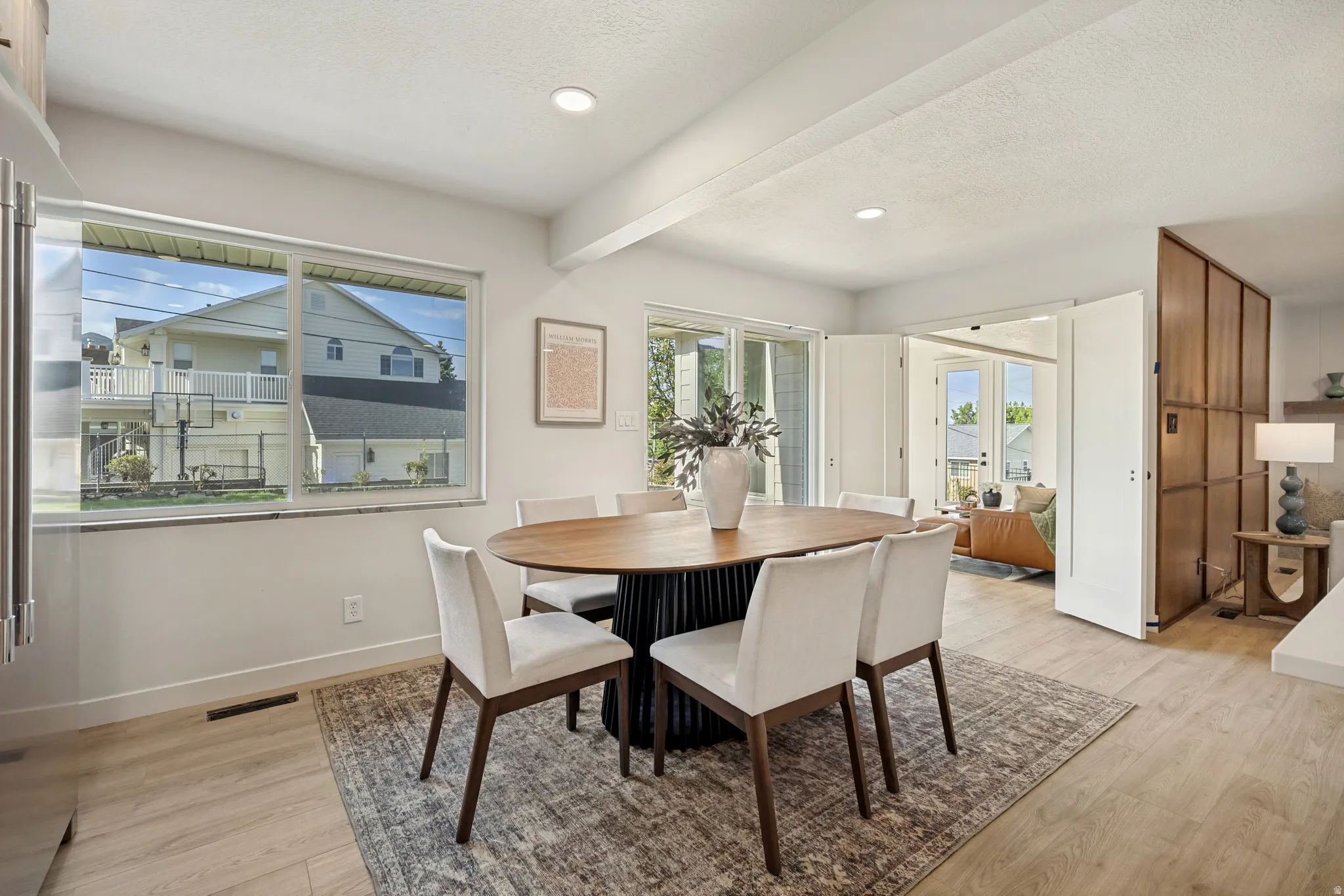 Spacious dining area featuring wood-finish flooring, recessed lighting, and a large window