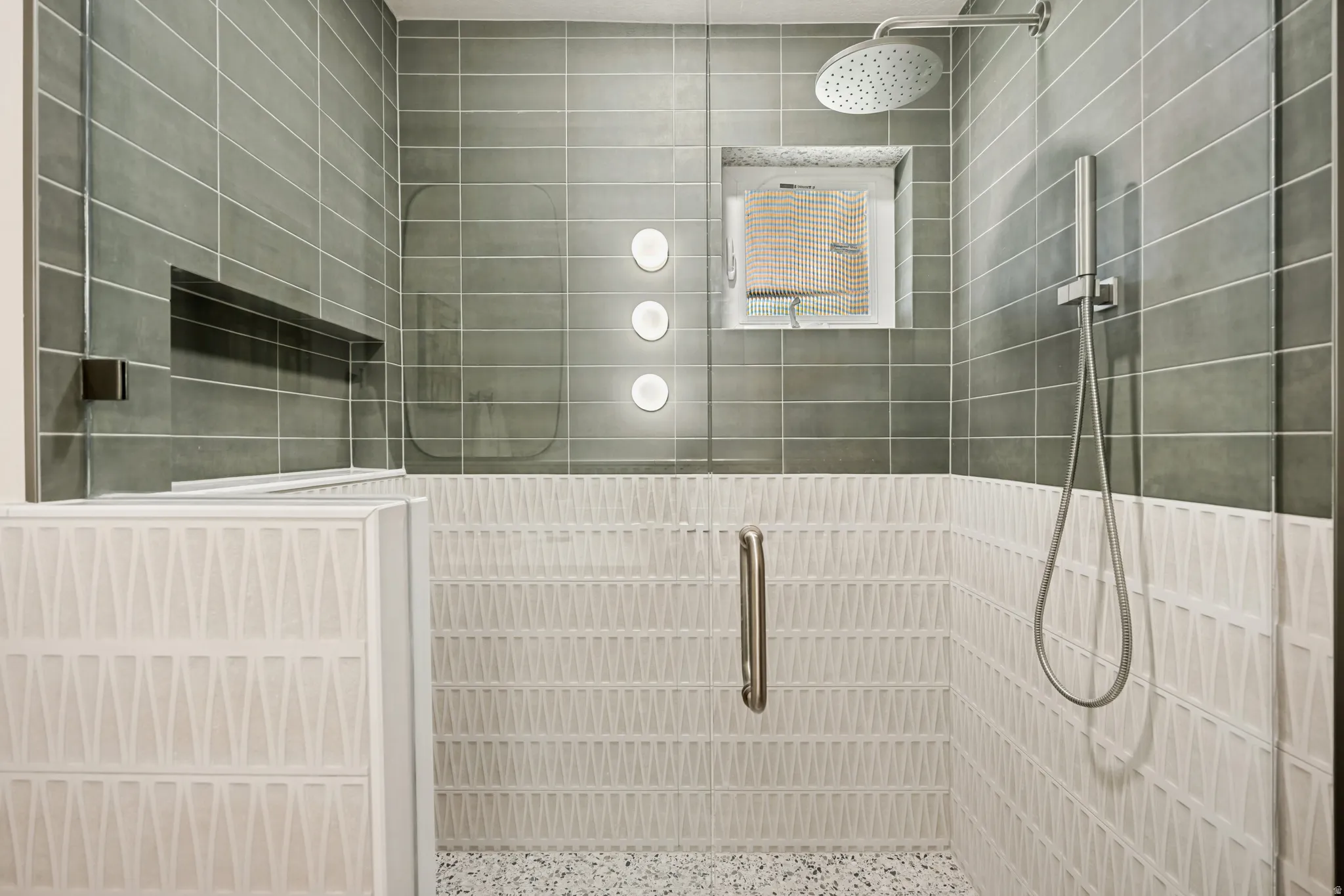 Walk-in shower featuring a rain shower head, handheld shower fixture, and a built-in niche