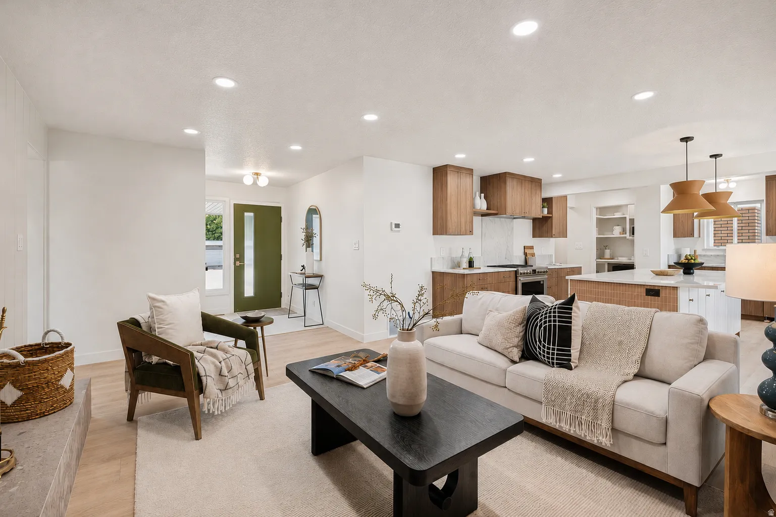 Open-concept living space featuring wood-finish flooring, recessed lighting, a modern kitchen with wood-tone cabinetry, and a central island with white countertops