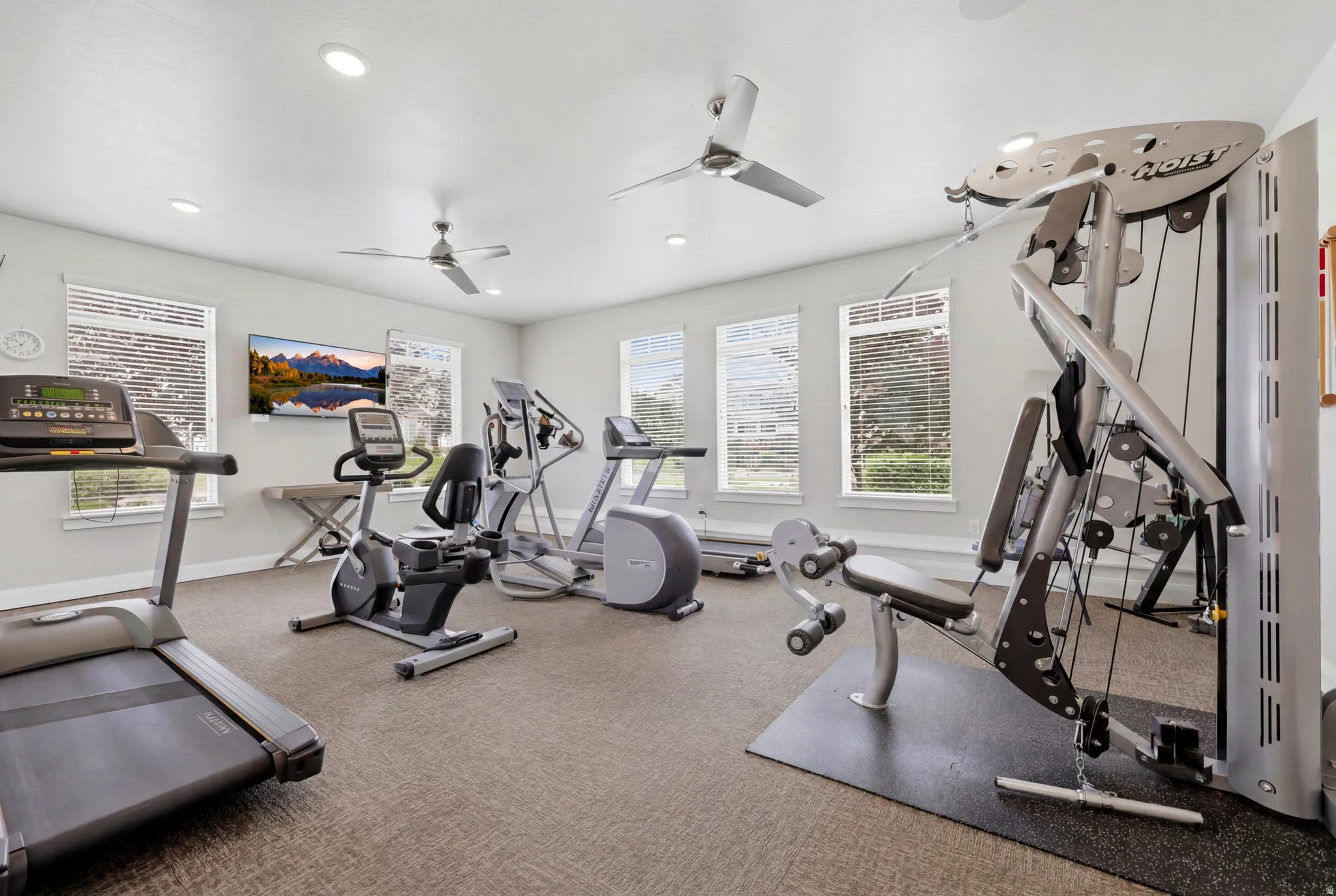 Dedicated fitness room featuring multiple windows, recessed lighting, and two ceiling fans