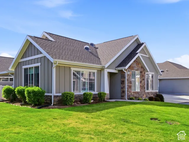 Contemporary exterior featuring gray siding, stone accents, and a dark shingle roof