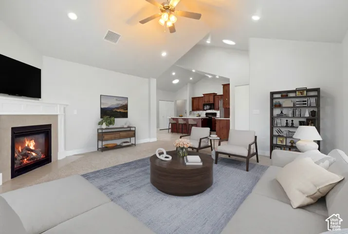 Vaulted ceiling with a ceiling fan, recessed lighting, fireplace with mantel, and carpet flooring