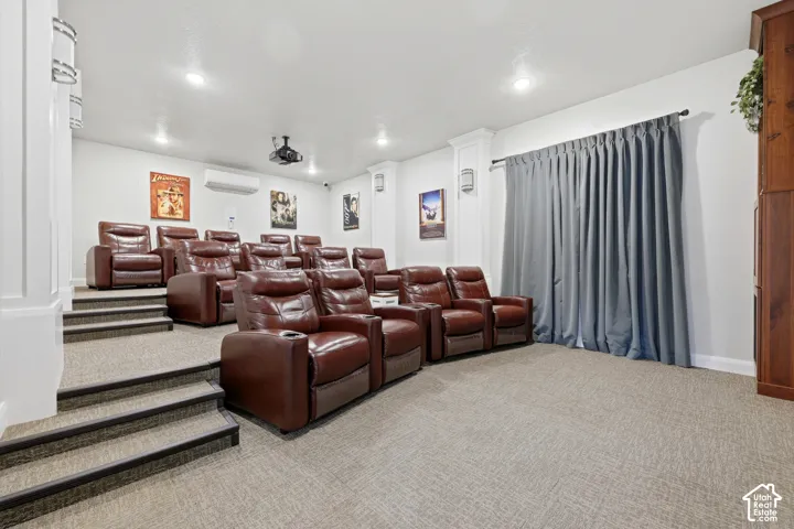 Theater room with tiered seating, wall-mounted projector, and full-length window treatments