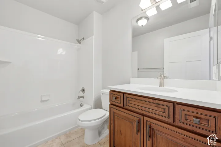 Bathroom featuring a wood-finish vanity with a white countertop and undermount sink