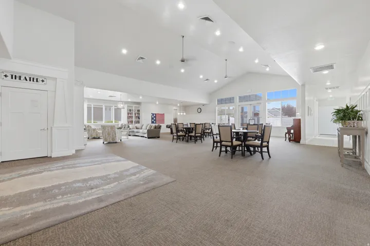 Spacious common area featuring vaulted ceilings, recessed lighting, large windows, and carpeted flooring