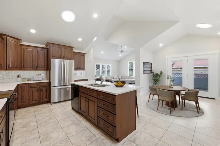 Kitchen featuring a center island, recessed lighting, tile flooring, stainless steel appliances, and wood cabinetry