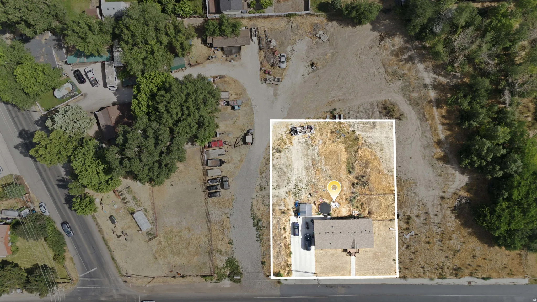 Aerial view showcasing a rectangular residential parcel with a single-story structure