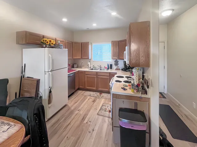 Kitchen featuring wood-finish flooring, wood cabinetry, recessed lighting, and a window for natural light