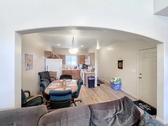 Arched entryway framing an open-concept living space with wood-finish flooring