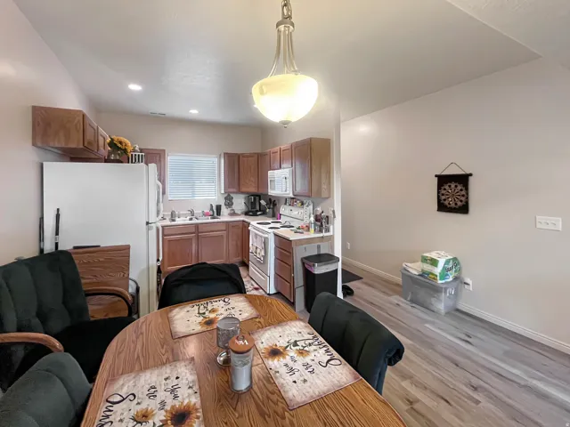 Kitchen featuring wood-finish flooring, wood cabinetry, recessed lighting, and a window for natural light