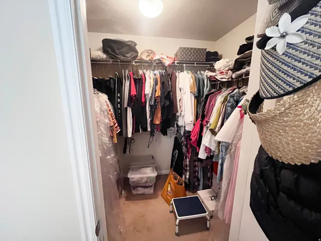 Primary bedroom walk-in closet and warm, natural light in the bedroom