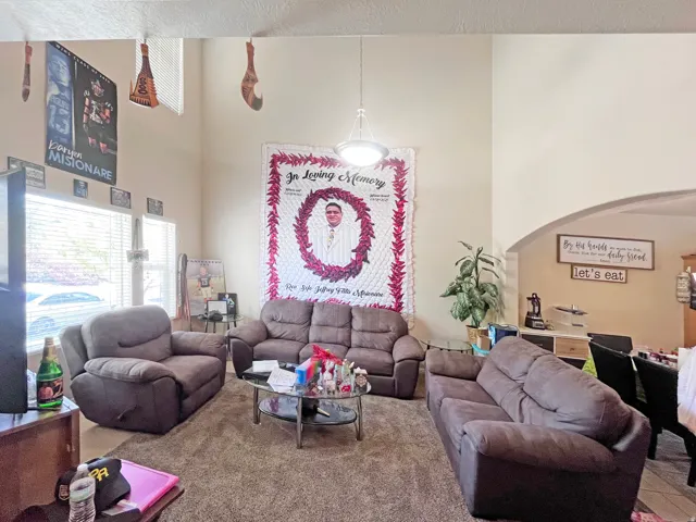 Living area featuring vaulted ceilings with ample, natural light and an arched entryway