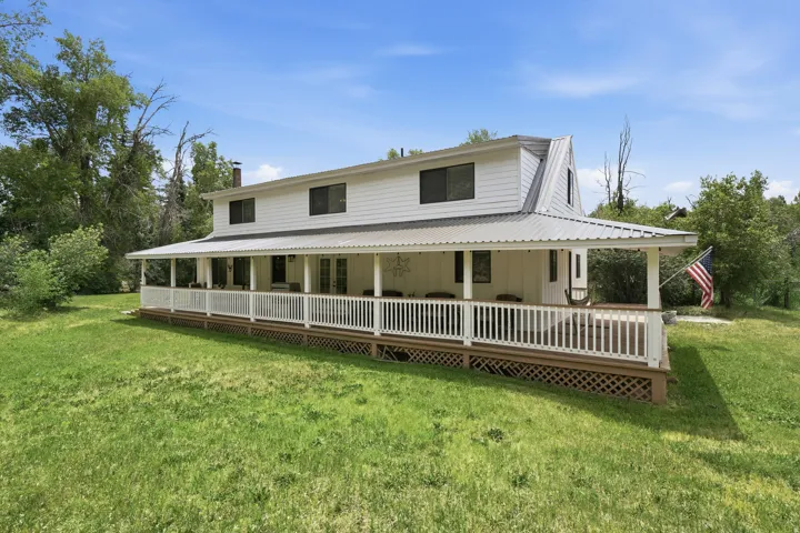 Two-story home with white horizontal siding and a gambrel roofline