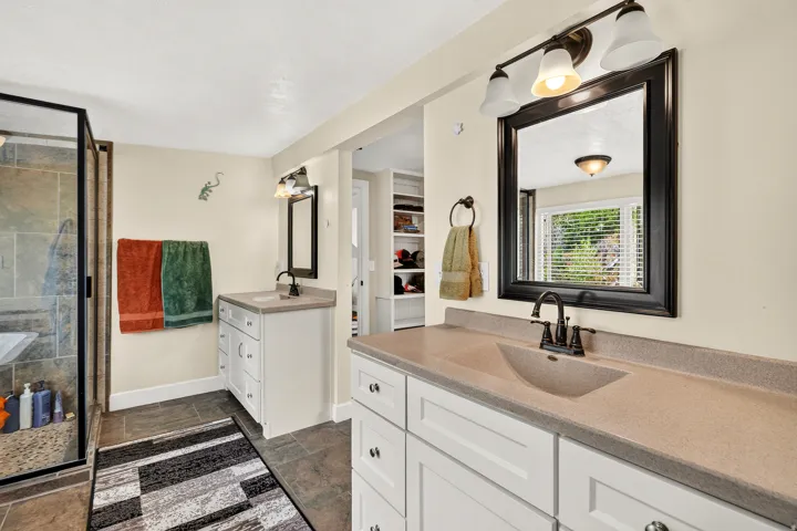 Dual vanity bathroom featuring integrated sinks and coordinating bronze-finish fixtures