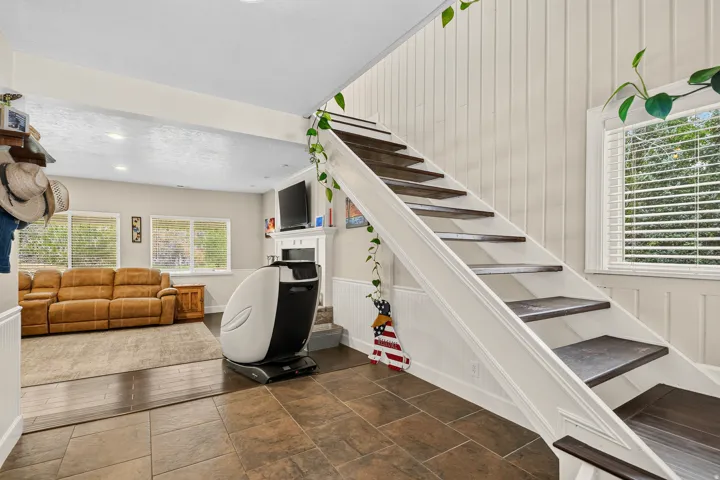 Open staircase with dark wood-finish treads and white risers, framed by vertical paneling