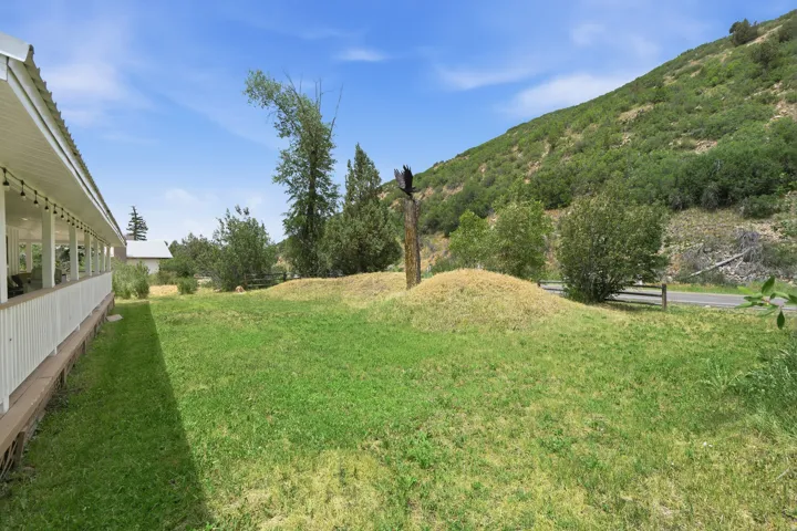 Expansive green lawn bordering a covered porch with white railings