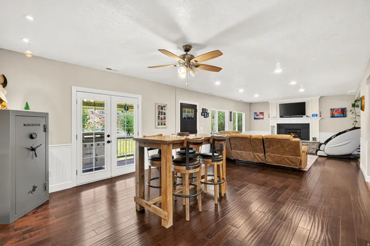 Spacious open-concept living area featuring rich wood-finish flooring, recessed lighting, and a ceiling fan
