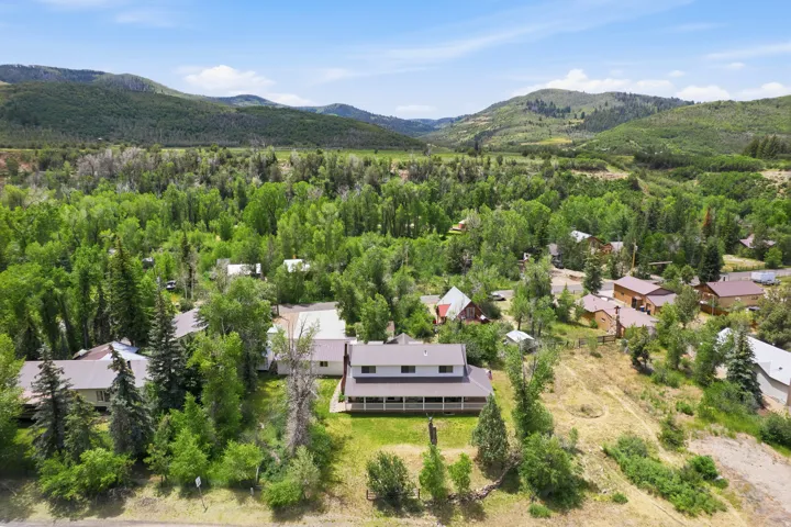 Expansive property featuring a two-story residence with a covered porch, set amidst a verdant landscape