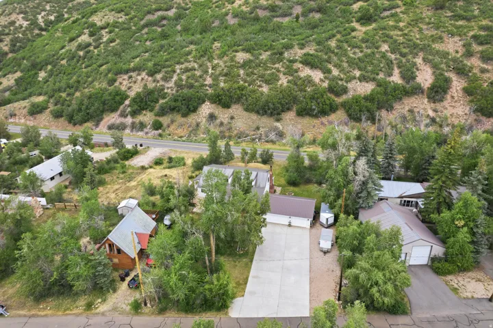 Aerial perspective showcasing multiple properties with surrounding mature trees