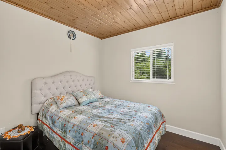 Room featuring a wood-finish plank ceiling and light neutral walls