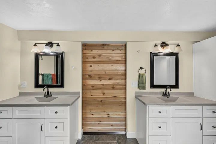 Dual vanity with white cabinetry, integrated sinks, and matte black fixtures