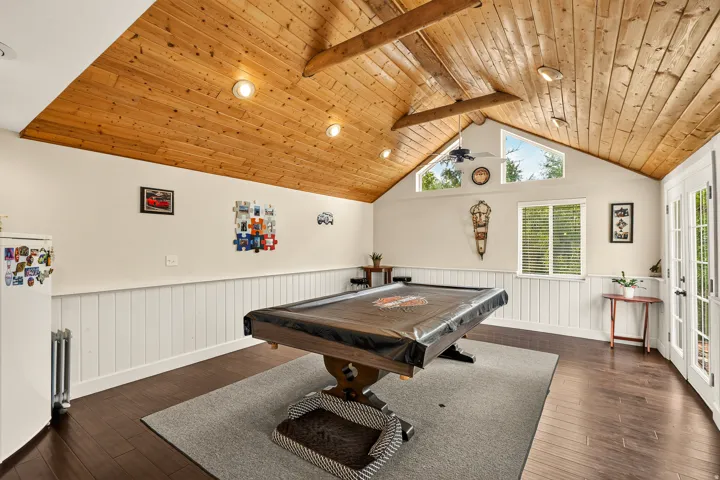 Vaulted wood-paneled ceiling with exposed beams and recessed lighting