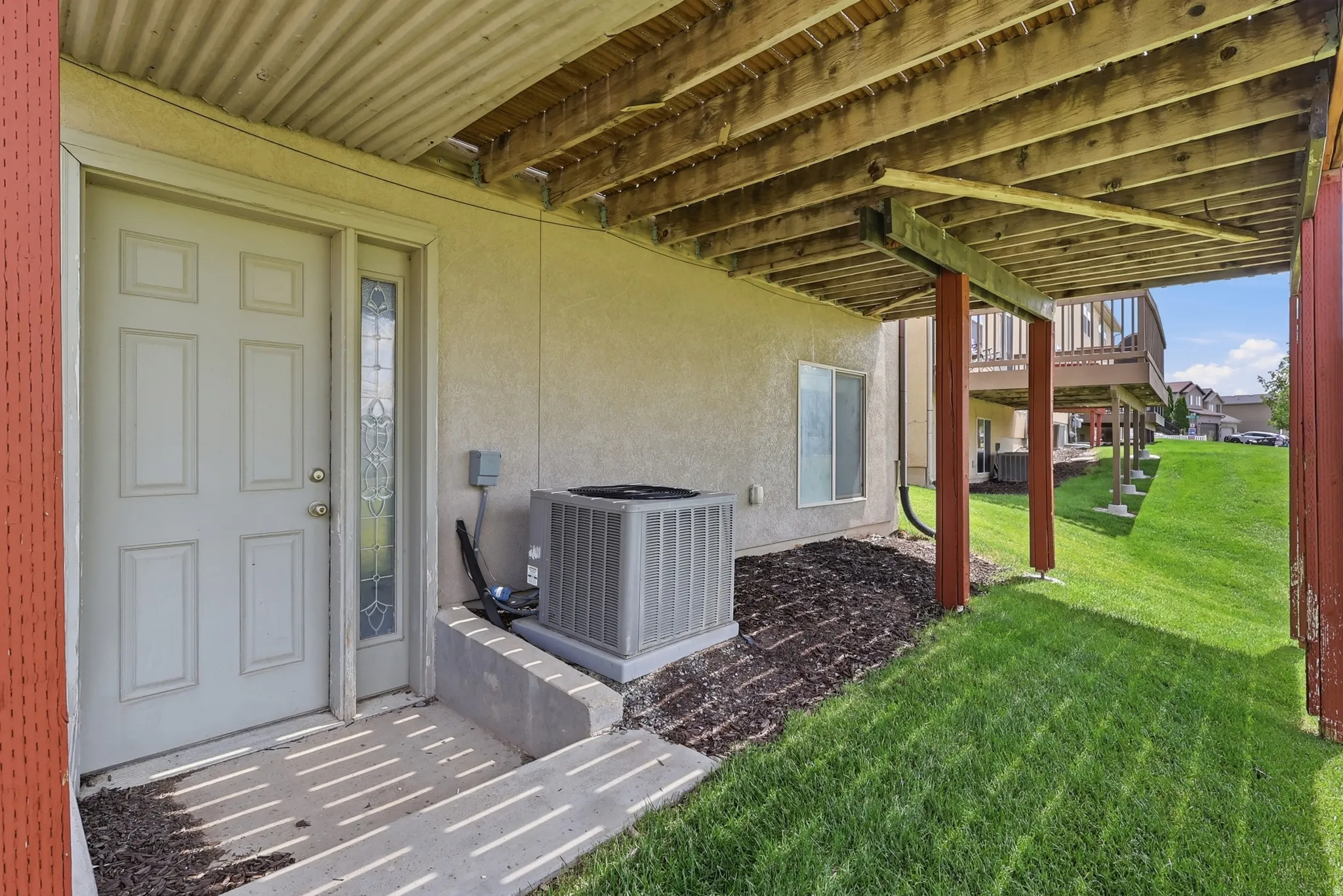 Patio area with a solid panel door featuring an ornate glass sidelight