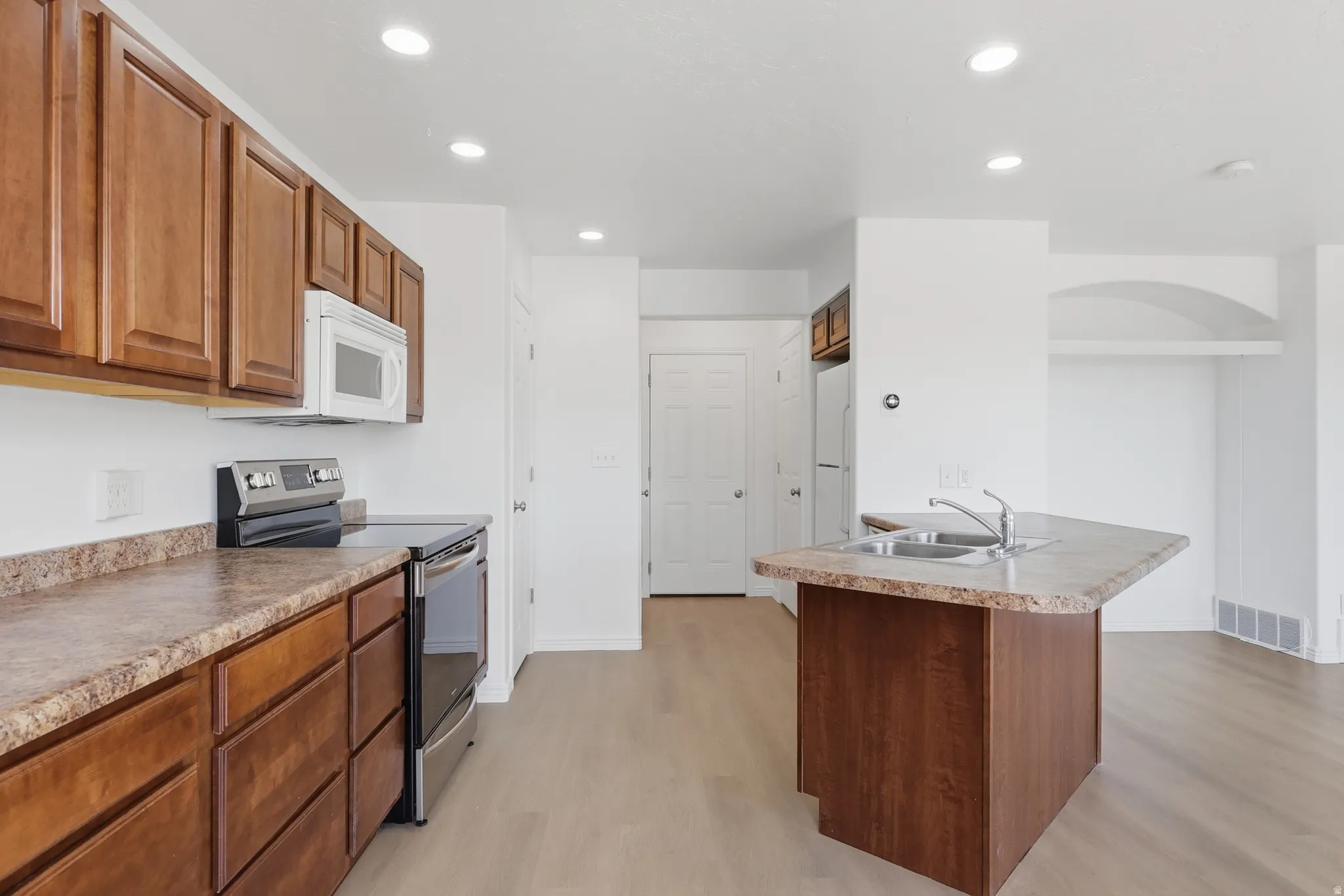 Kitchen featuring wood-finish cabinetry and light-toned wood-finish flooring