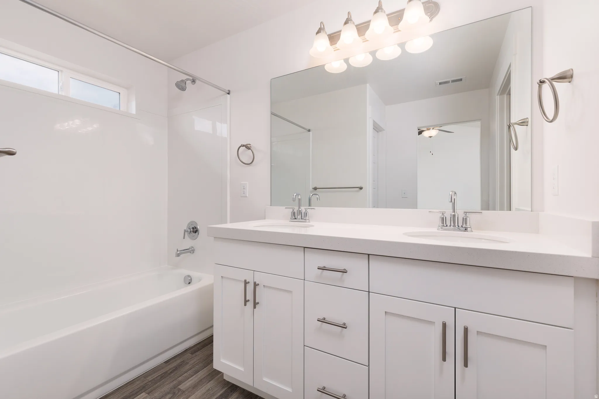 Bathroom featuring a dual-sink vanity with white cabinetry and a light-toned countertop