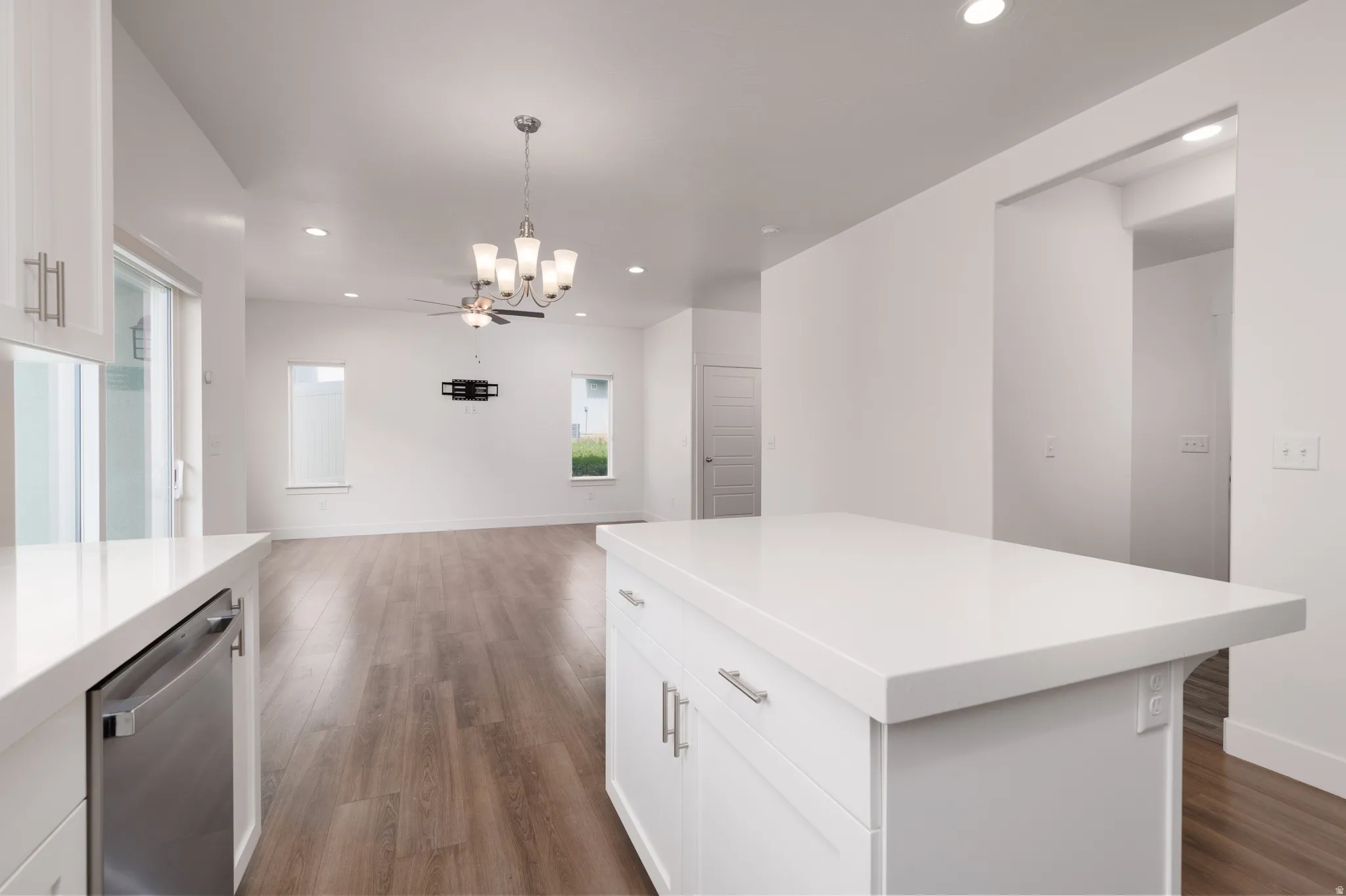 Kitchen island with white countertop, white cabinetry, and stainless steel hardware