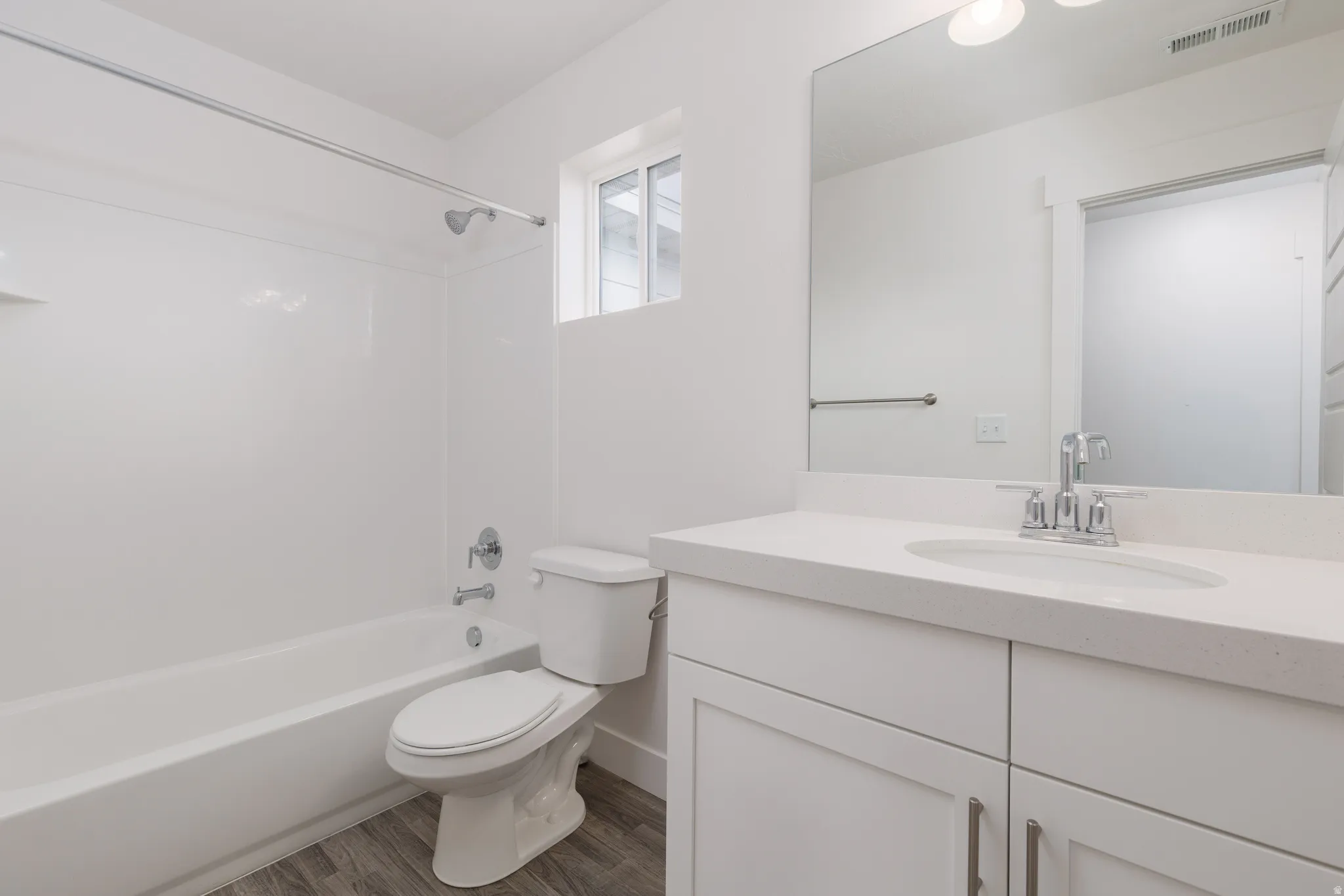 White vanity with integrated sink, light-colored countertop, and a chrome faucet