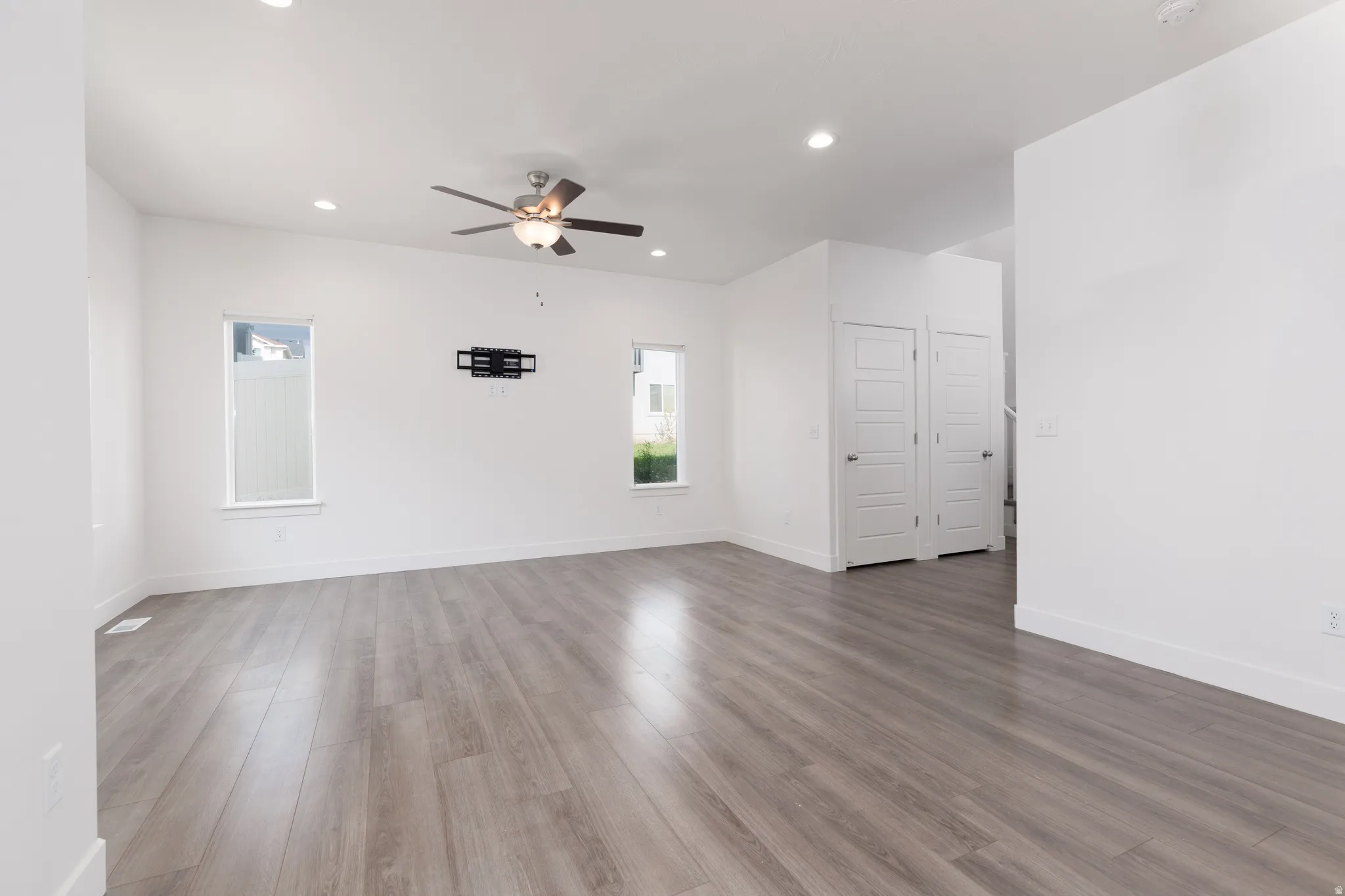 Bright interior space featuring wood-finish flooring, recessed lighting, and a ceiling fan