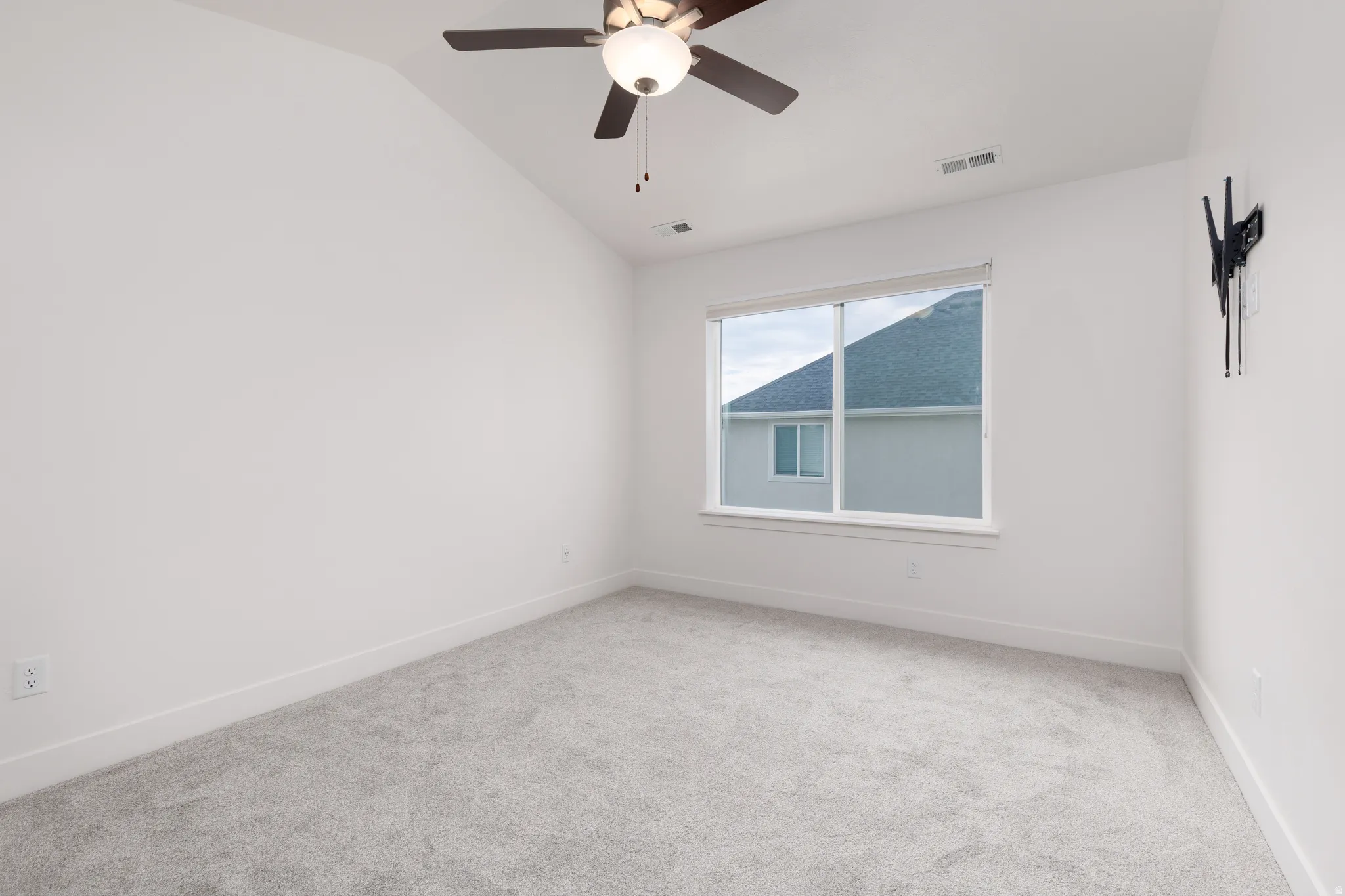 Neutral-toned carpet flooring complementing bright white walls, accented by a window with white trim
