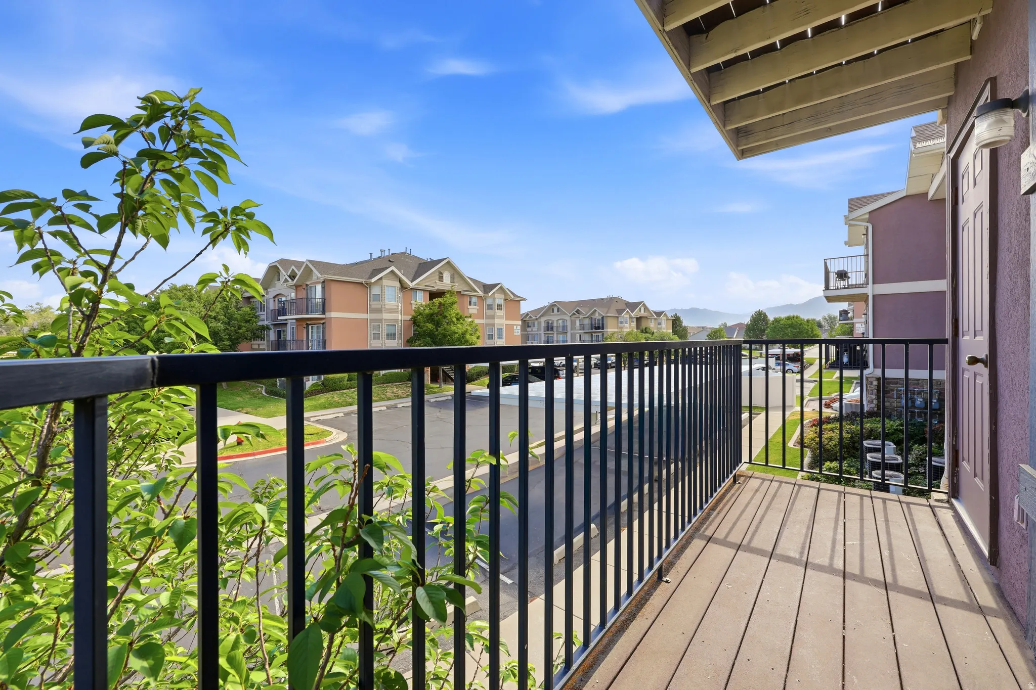 Private balcony featuring wood-finish flooring and a black metal railing