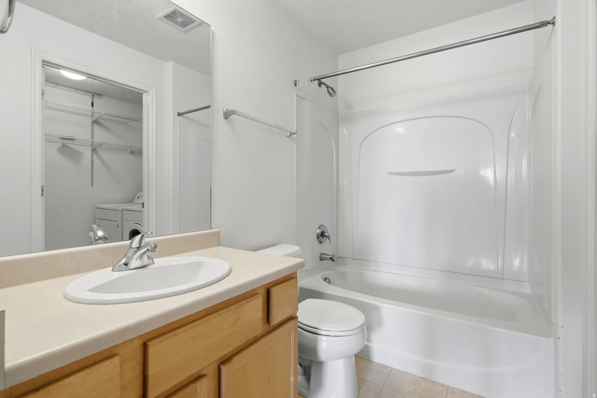 Bathroom featuring a light-toned vanity with an integrated sink and chrome faucet