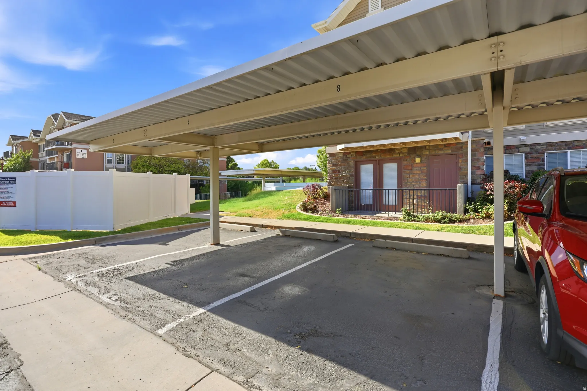 Assigned covered parking space featuring a metal carport structure and concrete parking surface