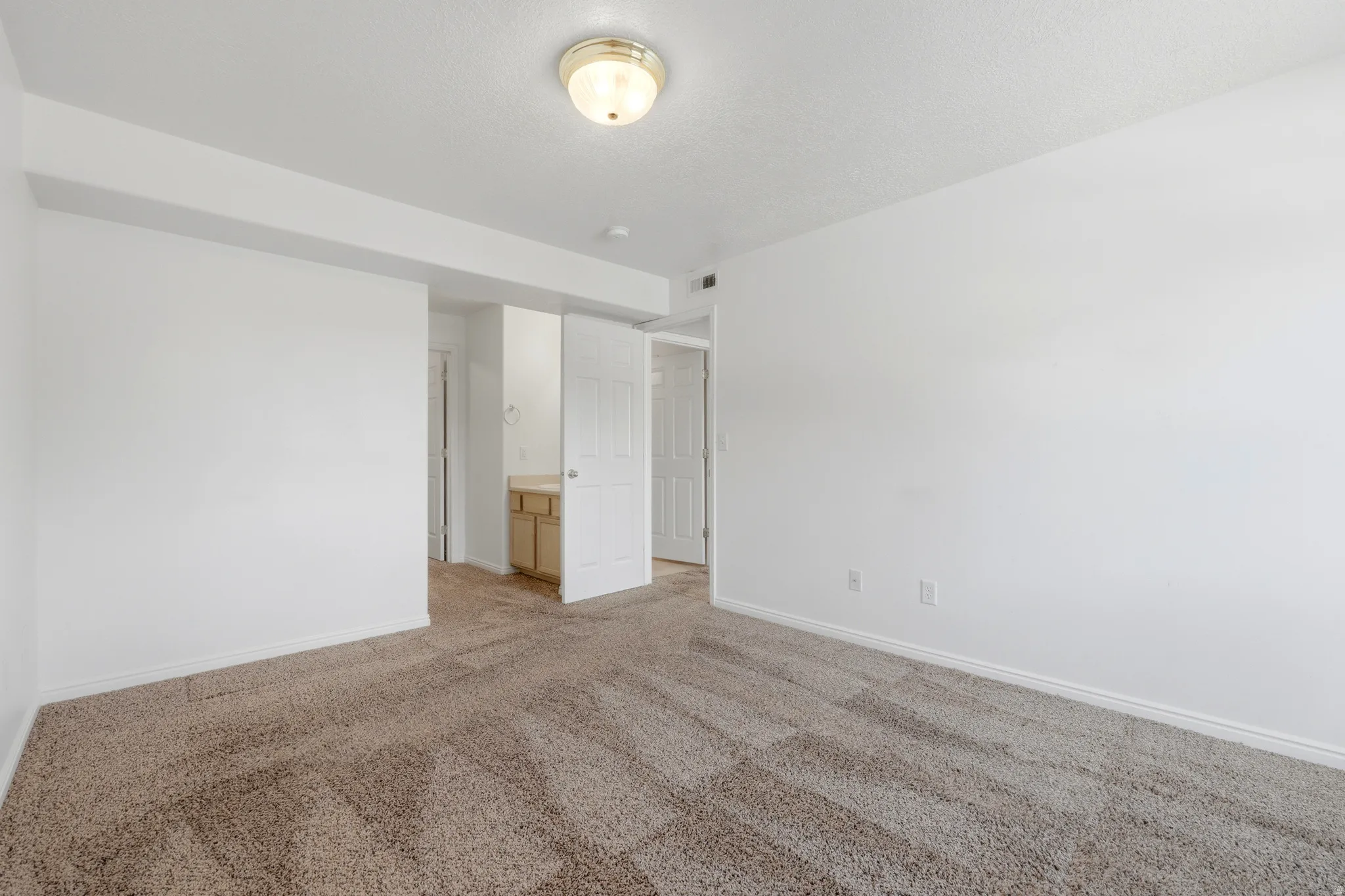 Carpeted interior space featuring light-colored walls and a semi-flush mount ceiling light