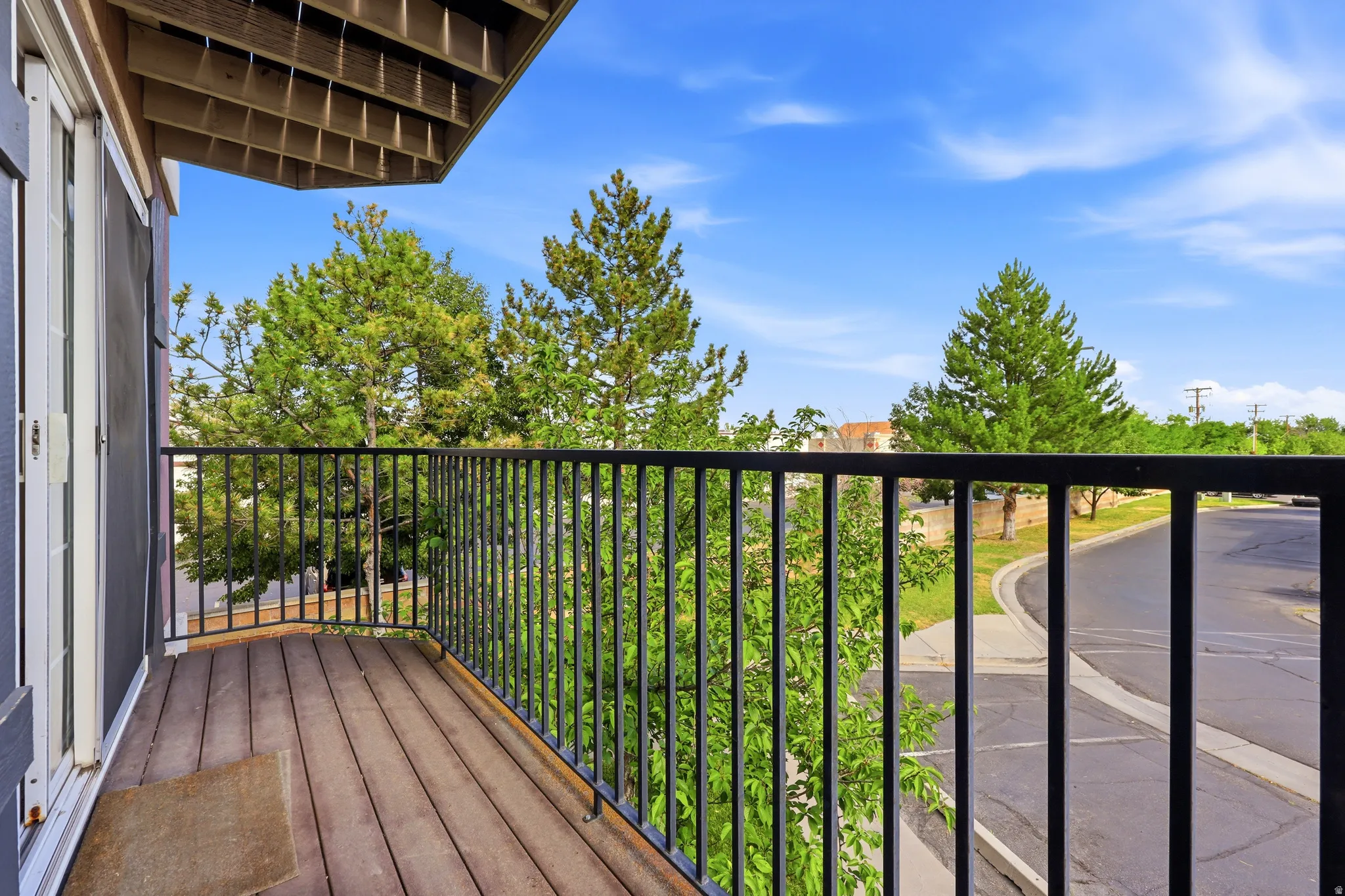 Private balcony featuring wood-finish flooring, black metal railing, and white double doors