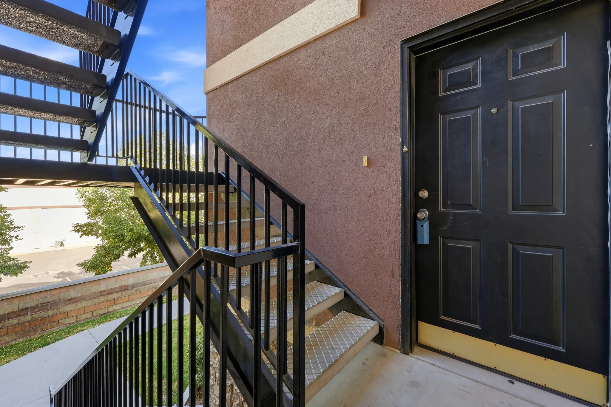 Exterior stucco wall in a neutral tone with a contrasting beige band