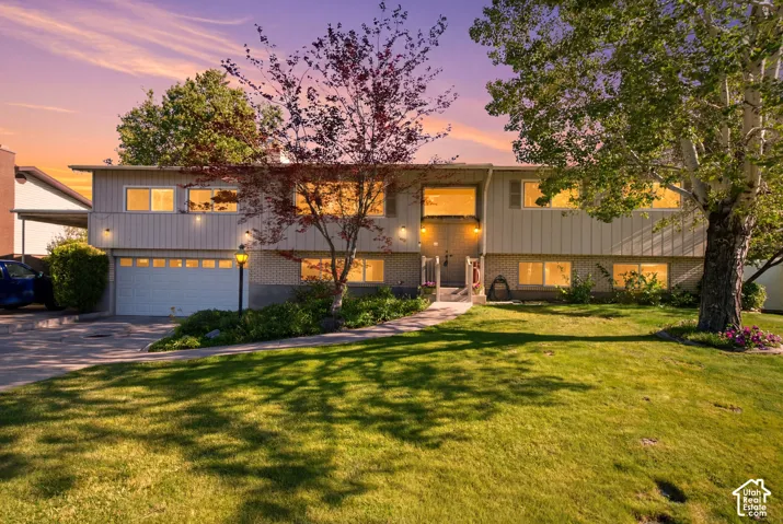 Split-level residence featuring a two-car garage, carport, and brick accents