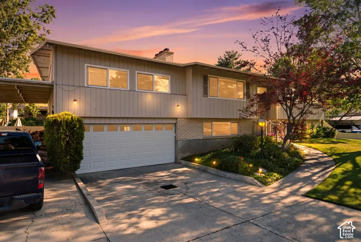 Contemporary split-level residence featuring a two-car garage, brick and siding exterior, and a covered carport