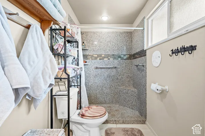 Walk-in shower with pebble-look tile, glass tile accent band, and built-in bench