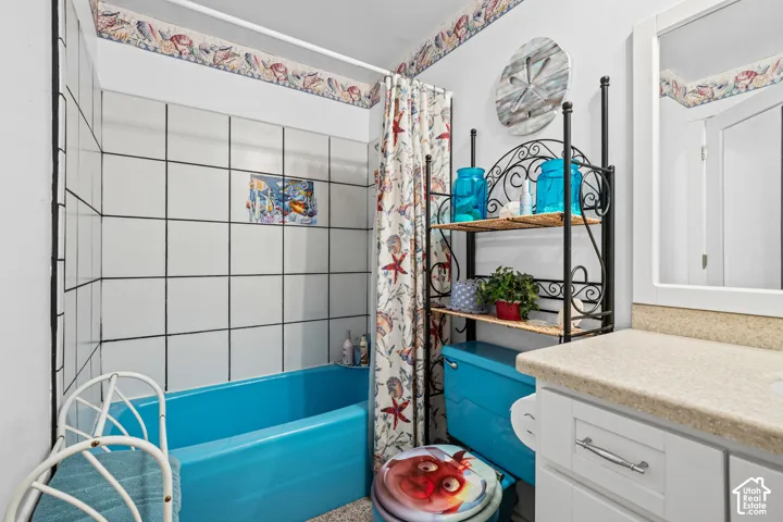 Bathroom featuring a white vanity with a light-colored countertop and framed mirror