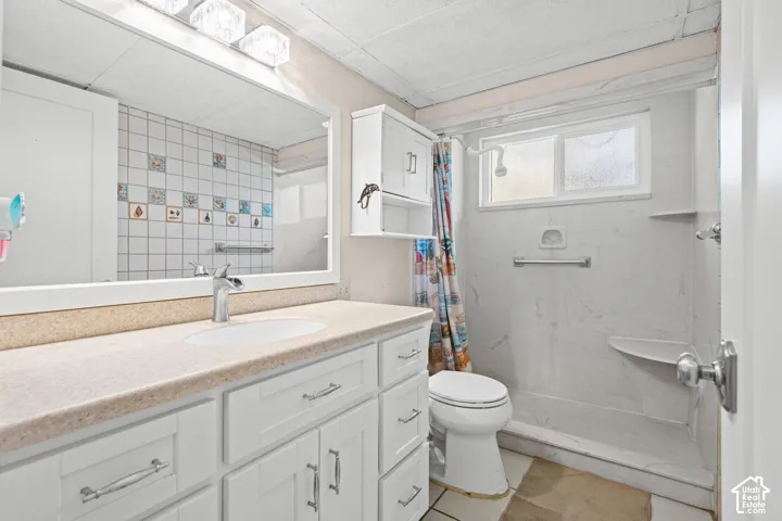 White shaker-style vanity with a light-toned countertop and an undermount sink